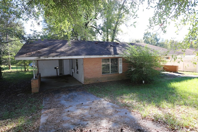 rear view of property featuring a yard and a carport