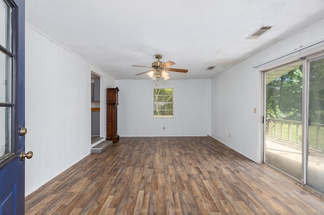 unfurnished room featuring crown molding, a textured ceiling, a ceiling fan, visible vents, and wood finished floors