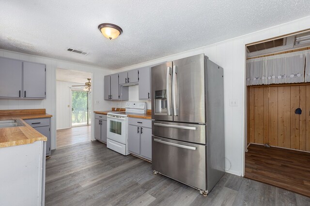 kitchen with visible vents, butcher block countertops, stainless steel refrigerator with ice dispenser, electric stove, and gray cabinets