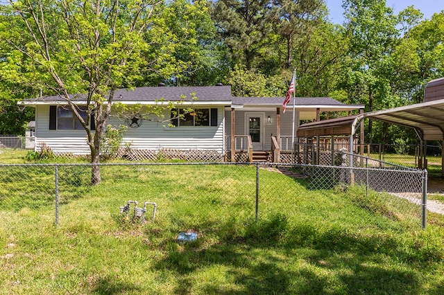 view of front of home with a detached carport, fence private yard, and a front lawn