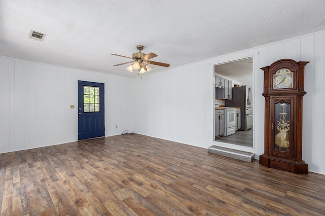 interior space featuring a textured ceiling, wood finished floors, ceiling fan, and visible vents