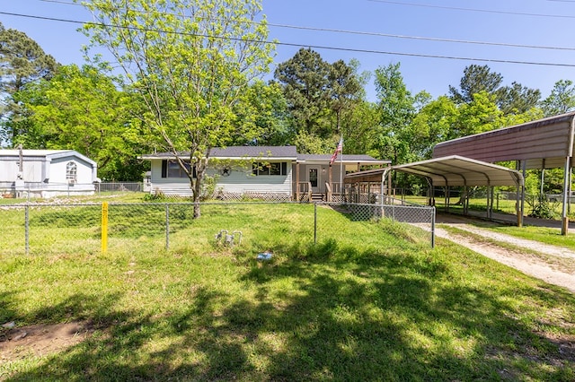 view of front of home featuring a detached carport, a front yard, fence private yard, and driveway