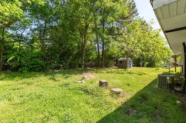 view of yard featuring a shed, central AC, and an outdoor structure