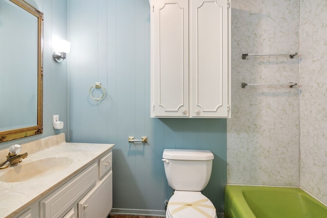 bathroom with vanity, a bathtub, and toilet