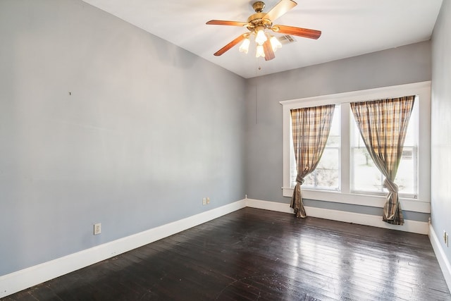 spare room featuring dark hardwood / wood-style flooring and ceiling fan