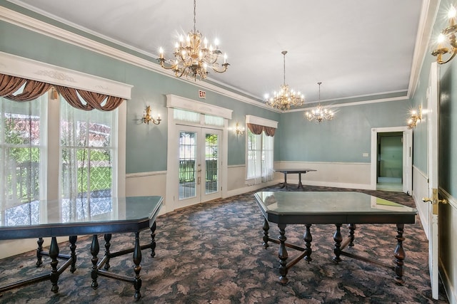 dining space featuring crown molding, french doors, a chandelier, and carpet