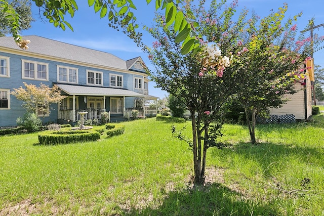 view of front facade featuring a front yard and covered porch