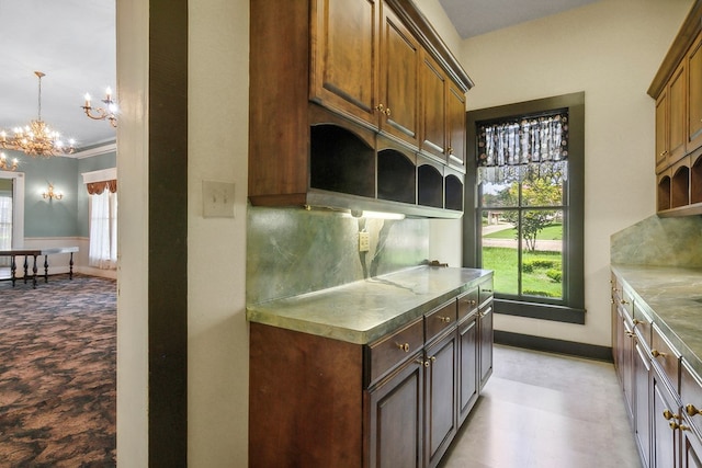 kitchen with crown molding, a healthy amount of sunlight, a chandelier, and hanging light fixtures