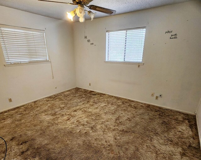 spare room featuring ceiling fan, carpet floors, and a textured ceiling