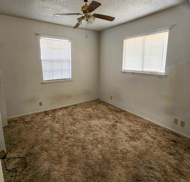 spare room featuring a textured ceiling, carpet floors, and ceiling fan