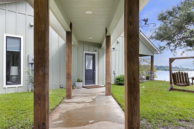 entrance to property featuring a lawn and a water view