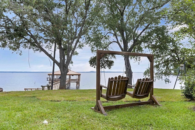 dock area with a lawn and a water view