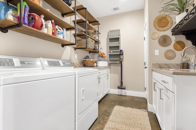 washroom with cabinets, washing machine and dryer, and sink