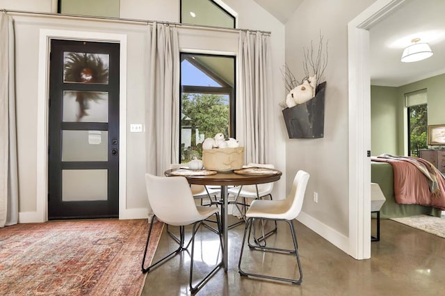 dining room with concrete floors and vaulted ceiling