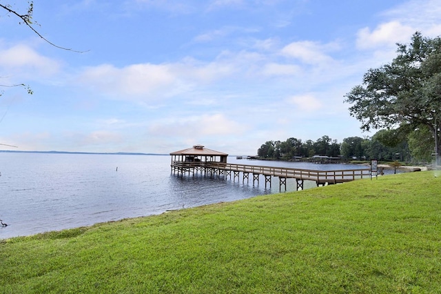 dock area with a yard and a water view