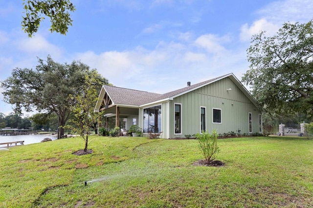 view of front of property with a water view and a front lawn