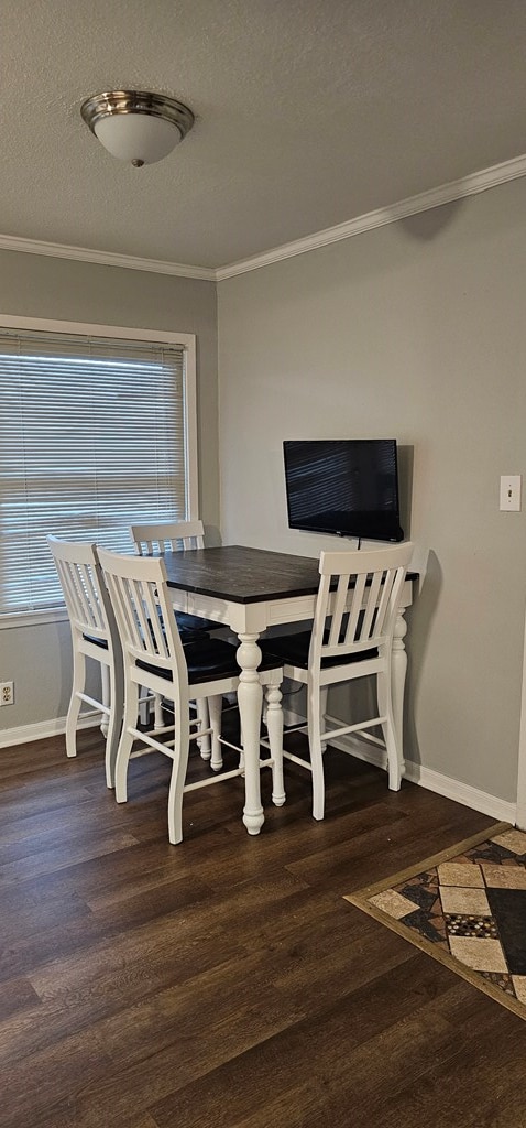 dining area with ornamental molding, a textured ceiling, and dark hardwood / wood-style flooring