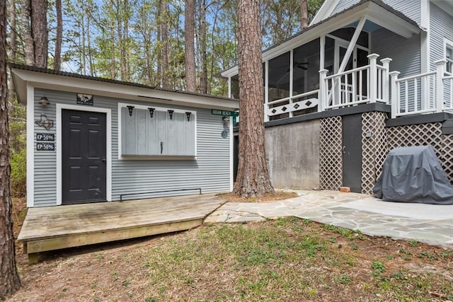 back of house with a sunroom and a deck