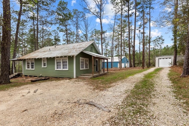 view of side of home with an outbuilding, a garage, and covered porch