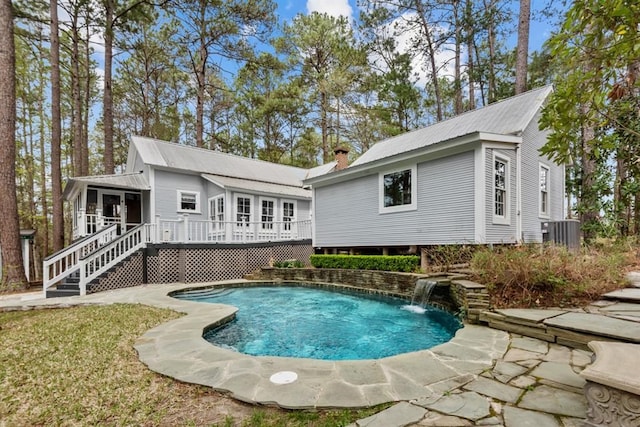 back of property with pool water feature, a swimming pool side deck, and central air condition unit