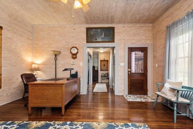 interior space with ceiling fan, wood walls, wooden ceiling, and dark hardwood / wood-style floors