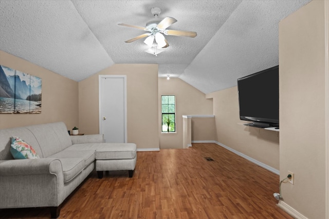 living room with a textured ceiling, ceiling fan, wood-type flooring, and vaulted ceiling