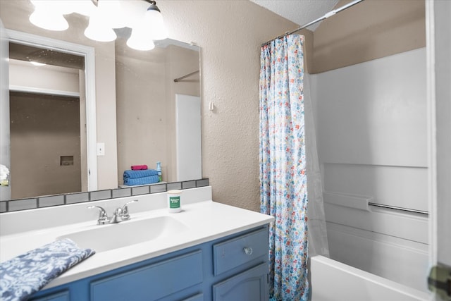 bathroom with shower / bath combination with curtain, a textured ceiling, and vanity