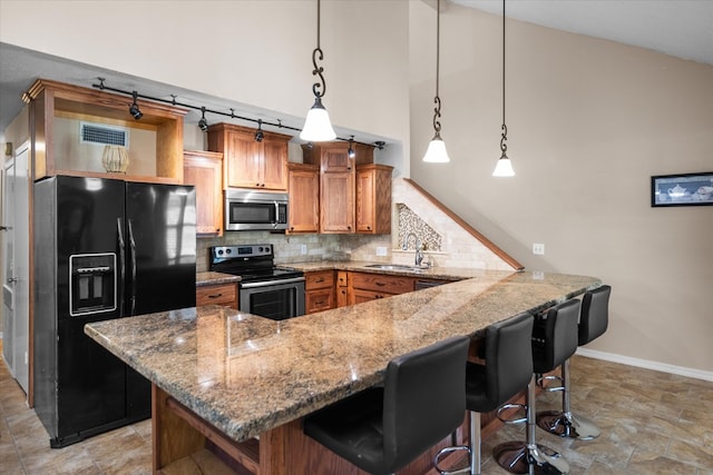 kitchen with a kitchen breakfast bar, stainless steel appliances, sink, decorative light fixtures, and high vaulted ceiling