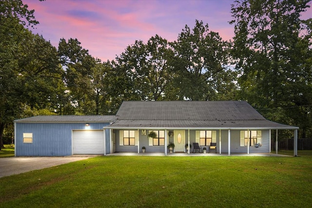 view of front of home with a porch, a yard, and a garage