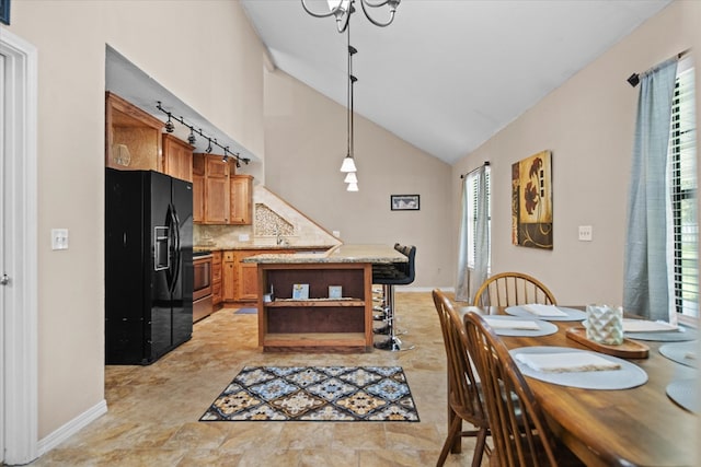 dining area featuring a chandelier and high vaulted ceiling