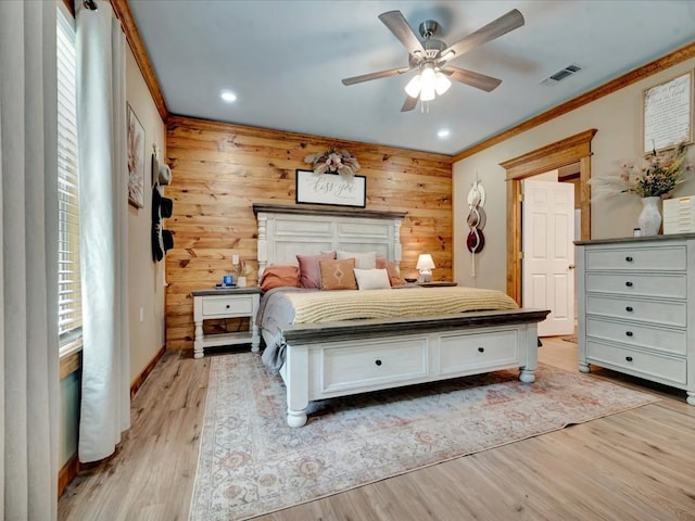 bedroom with visible vents, wooden walls, light wood-type flooring, recessed lighting, and ornamental molding