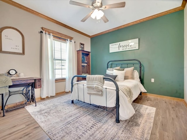 bedroom with crown molding, a ceiling fan, wood finished floors, and baseboards
