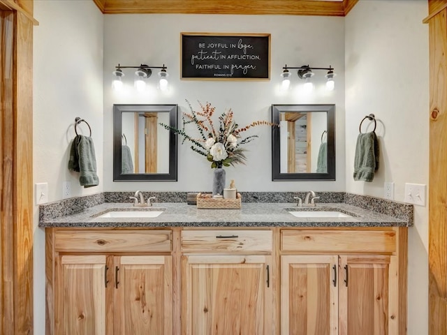 bathroom featuring double vanity, crown molding, and a sink