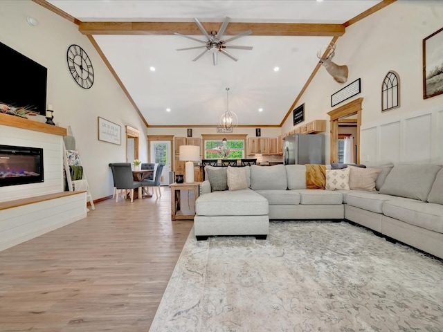 1003 Holubec St, Diboll, TX 75941 - living area featuring beam ceiling, high vaulted ceiling, a glass covered fireplace, light wood-type flooring, and a chandelier
