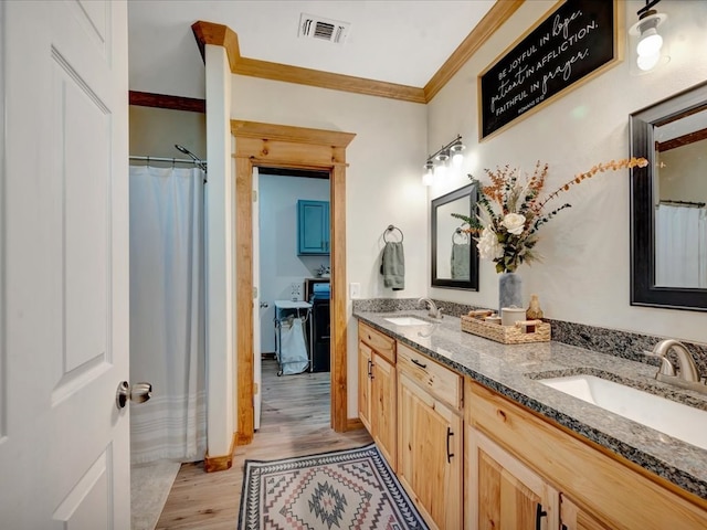 bathroom with crown molding, a sink, wood finished floors, and visible vents