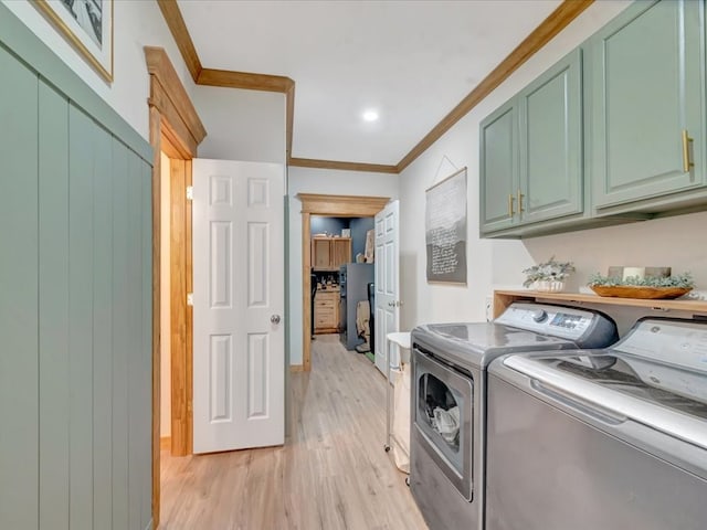 laundry room with separate washer and dryer, cabinet space, light wood finished floors, baseboards, and crown molding