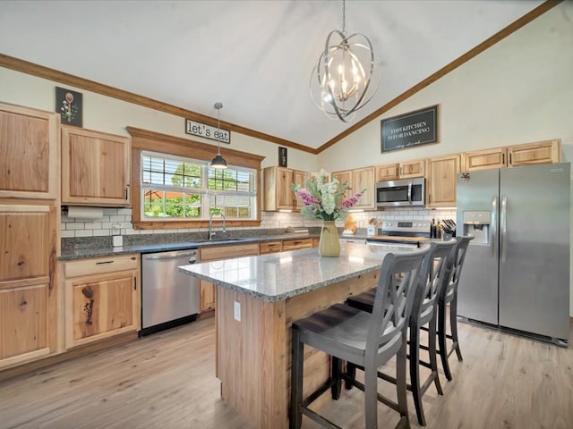 kitchen featuring a notable chandelier, appliances with stainless steel finishes, backsplash, and a sink