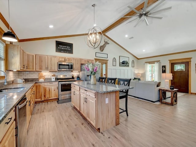 kitchen with light wood-style flooring, light brown cabinetry, a breakfast bar area, stainless steel appliances, and a sink