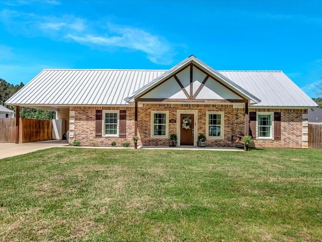 view of front of home with brick siding, a carport, a front lawn, and fence