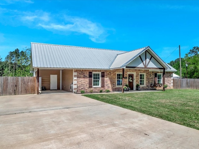 view of front of house with brick siding, fence, a front lawn, and concrete driveway