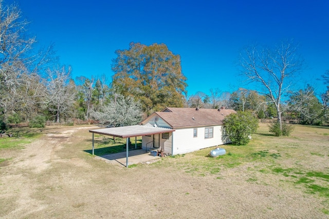 rear view of property with a lawn and a carport