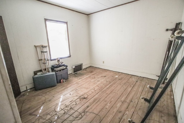 empty room featuring ornamental molding and wood-type flooring