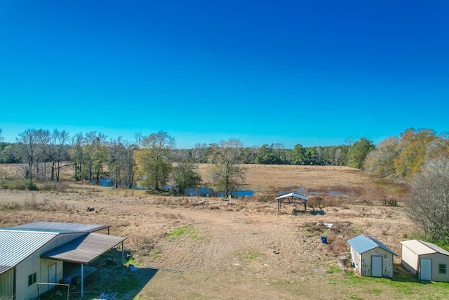 view of yard featuring a rural view and a storage unit