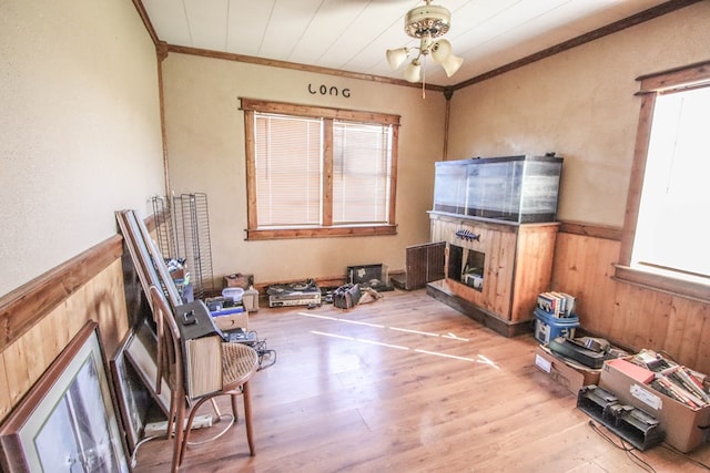 living area featuring plenty of natural light, wainscoting, and wood finished floors