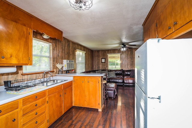 496 County Road 486, Broaddus, TX 75929 - kitchen with freestanding refrigerator, a sink, a peninsula, a ceiling fan, and dark wood-style flooring