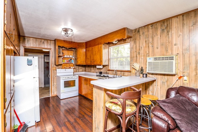496 County Road 486, Broaddus, TX 75929 - kitchen featuring white appliances, wooden walls, a wall mounted air conditioner, a peninsula, and light countertops