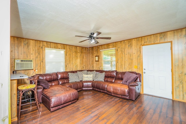 496 County Road 486, Broaddus, TX 75929 - living area with ceiling fan, a wall mounted AC, wooden walls, hardwood / wood-style floors, and a textured ceiling