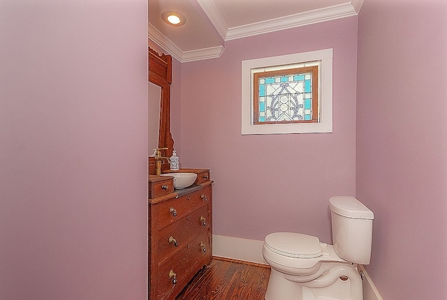 bathroom with crown molding, hardwood / wood-style floors, vanity, and toilet