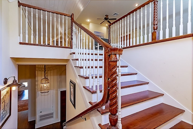 staircase with wood-type flooring and ceiling fan with notable chandelier