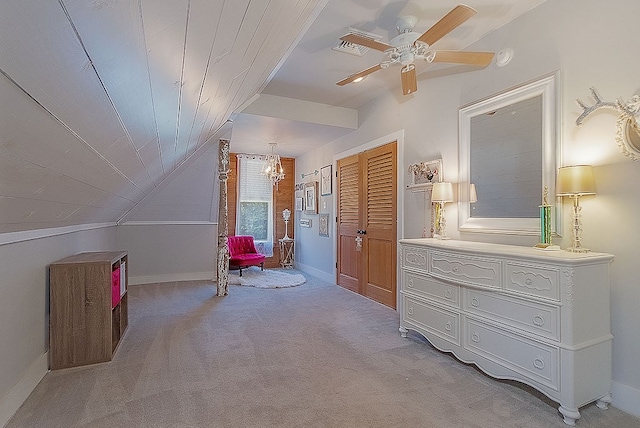 bedroom with ceiling fan with notable chandelier, lofted ceiling, light carpet, and a closet